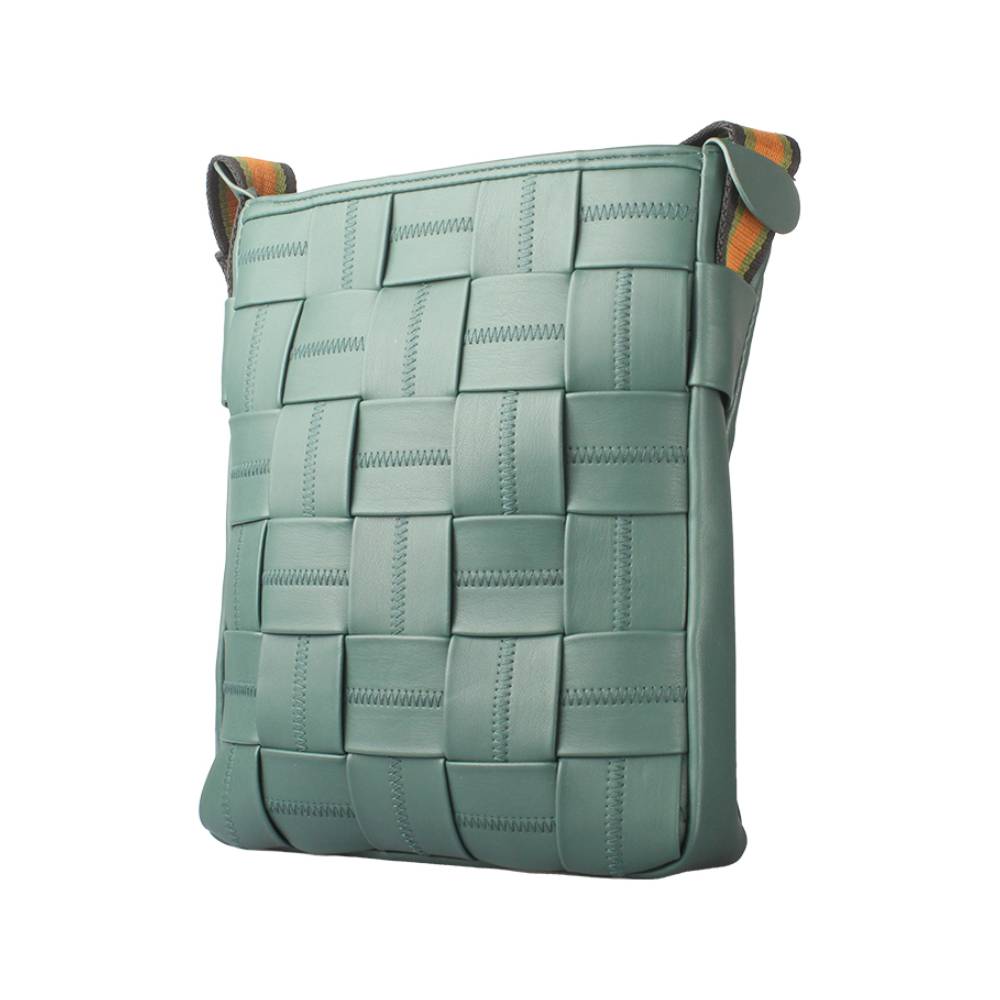 Angled side view of a teal woven leather crossbody bag, displaying the front woven pattern and striped shoulder strap.