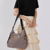 Gray nylon hobo crossbody bag worn by a model, adjustable shoulder strap, casual everyday fashion for work and travel.