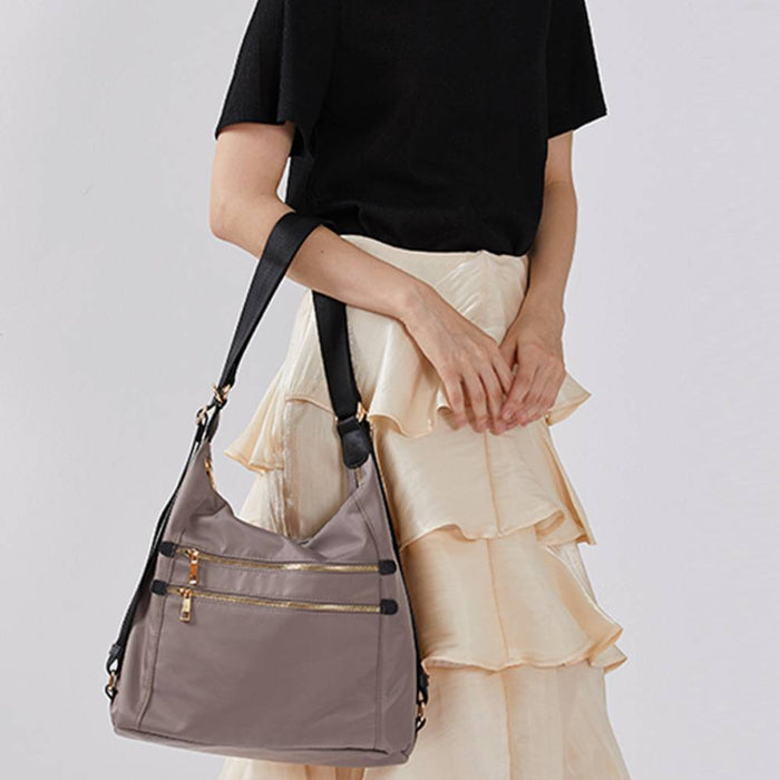 Gray nylon hobo crossbody bag worn by a model, adjustable shoulder strap, casual everyday fashion for work and travel.