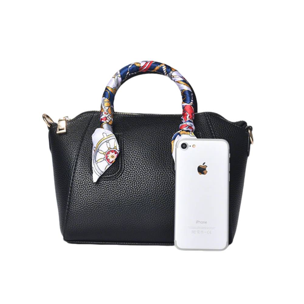 Front view of a black pebbled leather satchel handbag with a decorative nautical scarf-wrapped handle, shown with a smartphone to demonstrate compact size and capacity.
