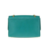 Back view of teal green leather flap bag with gold chain strap attachment, showing clean design and durable stitching.