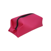 Bold pink toiletry bag with black zipper and soft-sided structure, perfect for organizing cosmetics and travel items.