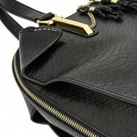 Close-up of black snakeskin-embossed leather texture and gold hardware, highlighting premium material and craftsmanship.