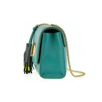 Green profile of beige leather crossbody clutch with gold chain and tassel details, showing compact structured shape.