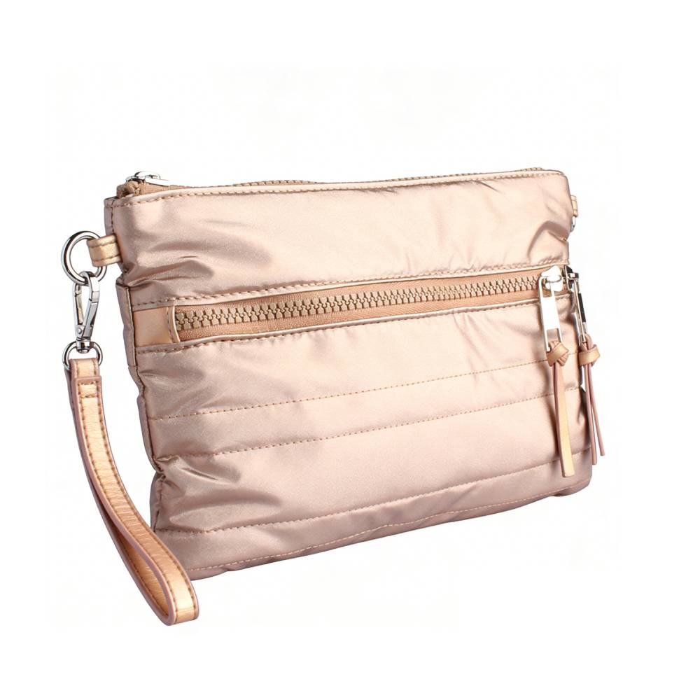 Side angled view of a rose gold quilted crossbody bag, highlighting the detachable wristlet strap and dual zipper pulls with leather tassels.
