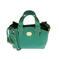 Close-up of teal green leather bag with gold octagonal emblem and contrast stitching, highlighting premium material and craftsmanship.