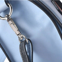 Close-up of silver metal hardware connecting the strap to light blue leather crossbody bag, highlighting sturdy craftsmanship.