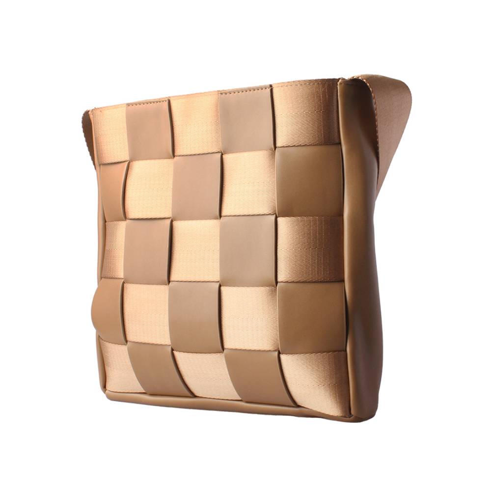 Side view of a tan woven crossbody bag, featuring a checkered pattern of leather and webbing straps, highlighting textured craftsmanship.