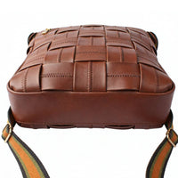 Side view of a brown woven leather crossbody bag, featuring a checkered pattern with decorative stitching and a striped adjustable shoulder strap.